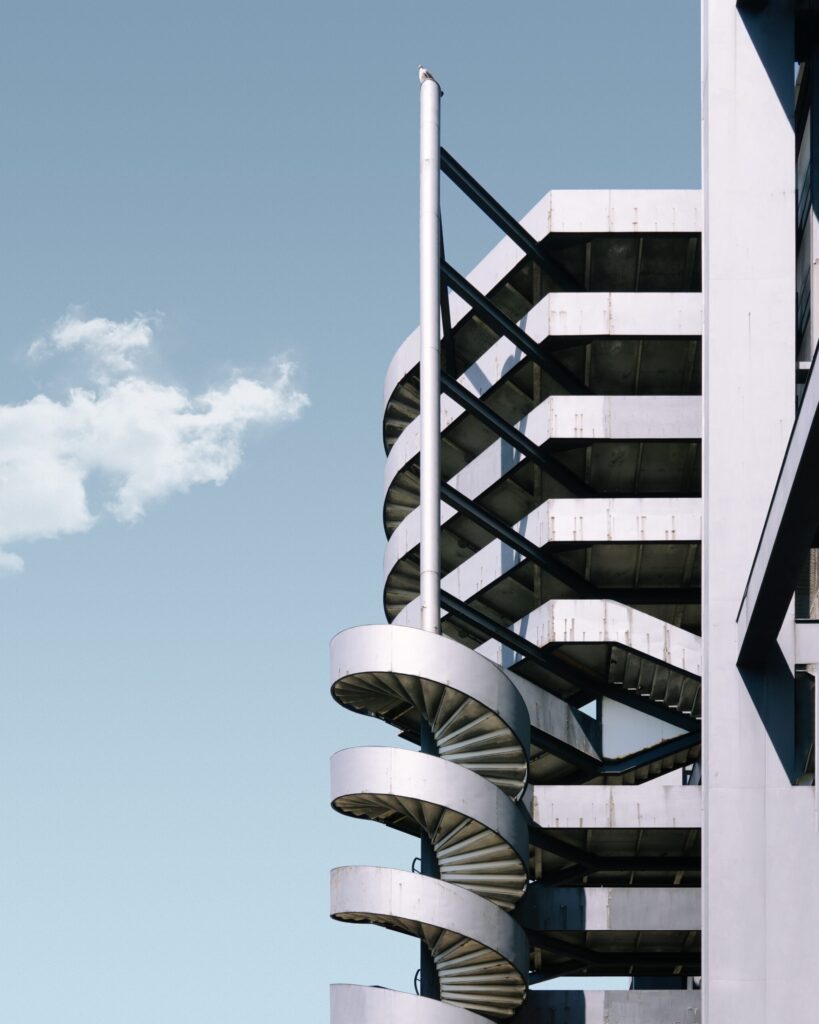 vertical shot of a metal building and the stairway under the blue sky